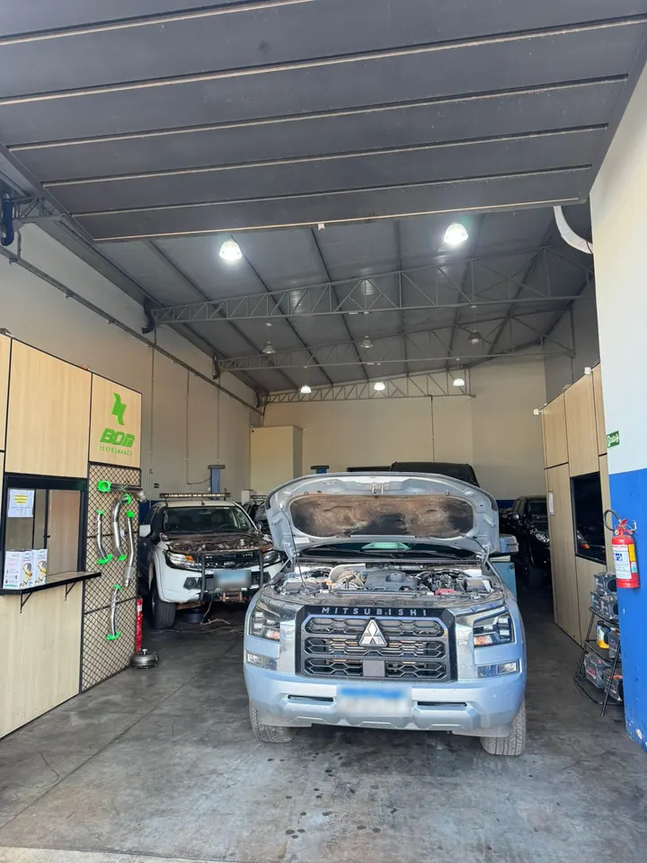 Picape Mitsubishi Triton diesel com o capô aberto no box da JM Paternez